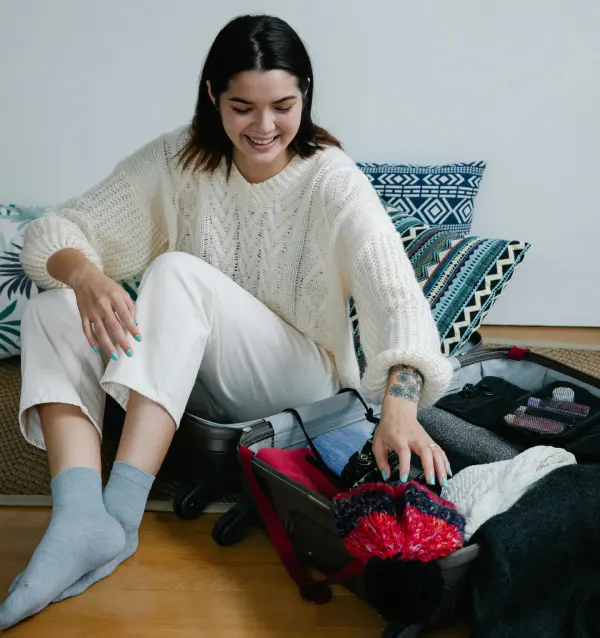 a woman wearing a winter white sweater packing her things