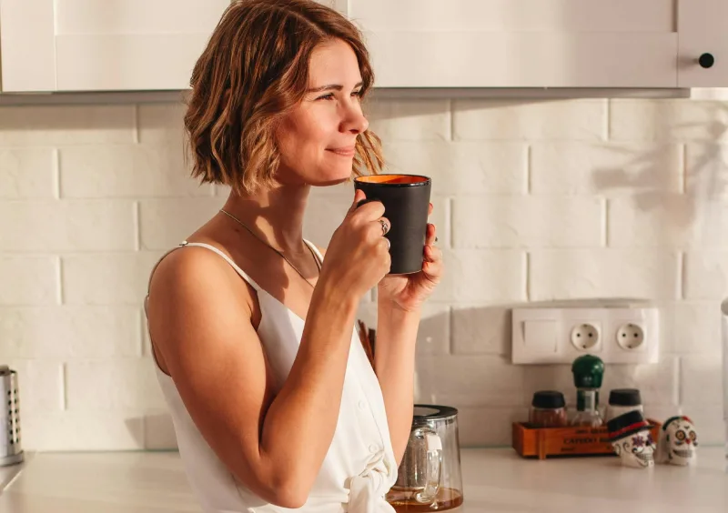 a woman looking at the window about to prepare breakfast, she has pcos