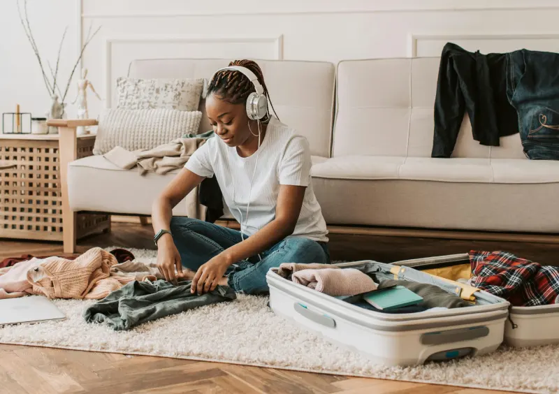 a black woman, wearing a headset, sitting on the floor packing her things