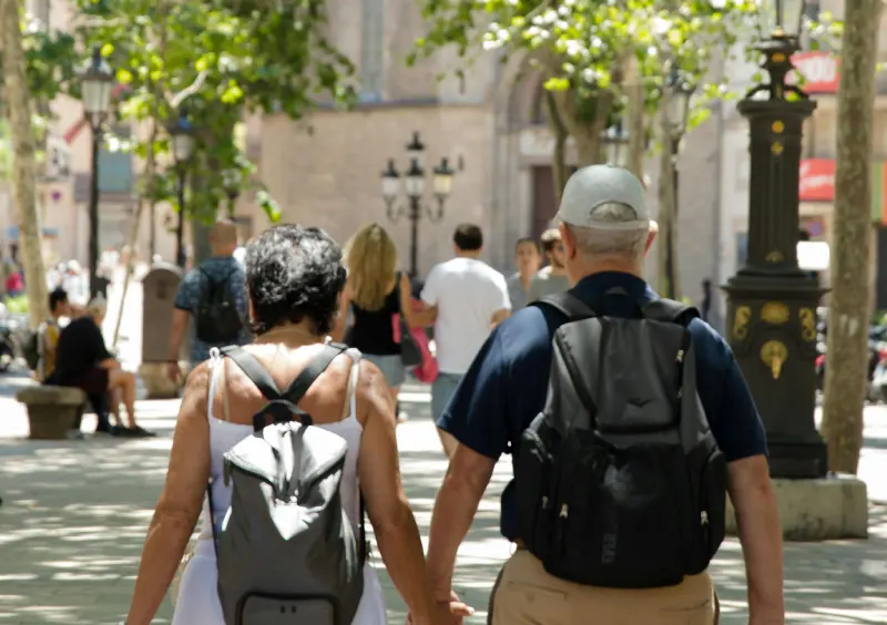 2 old couple walking while holding their hands