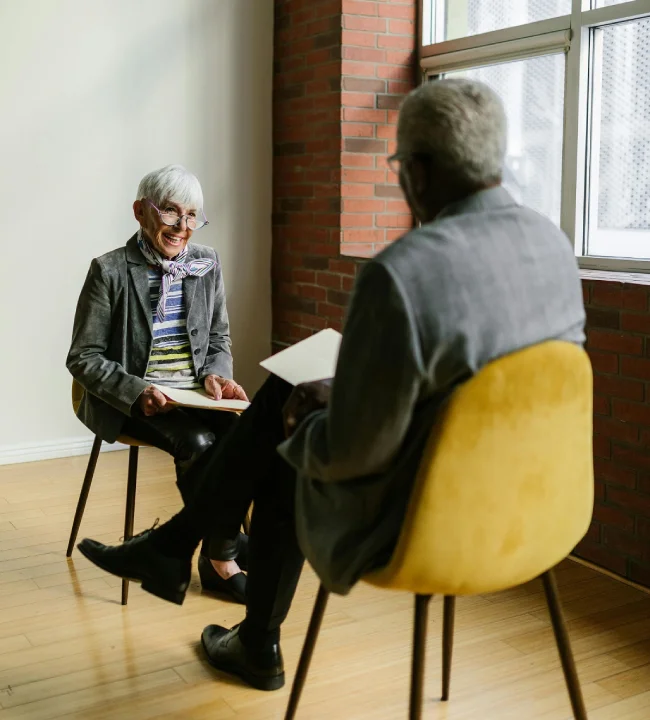 an old woman sitting in front of an interviewer