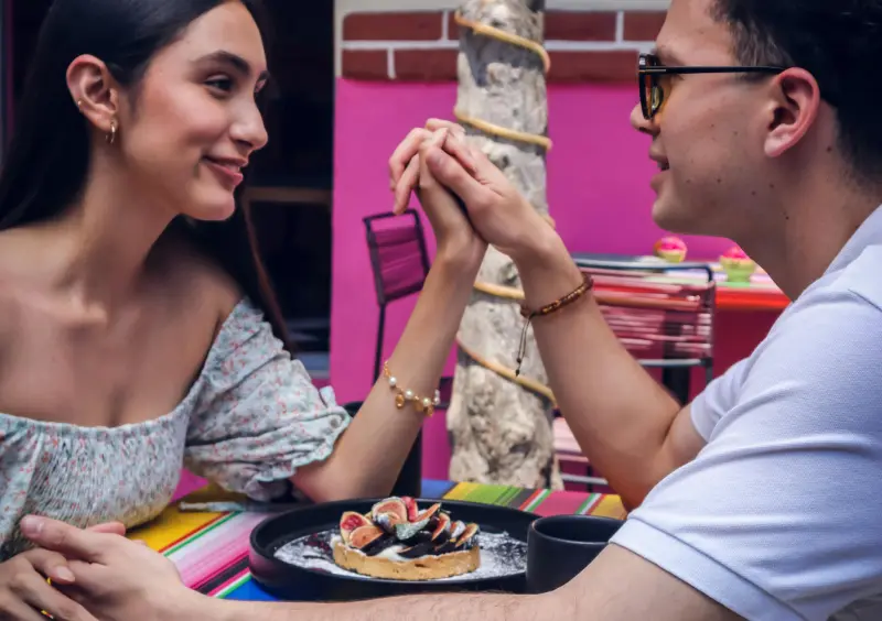 cheap date ideas - a couple holding their hands while dining out