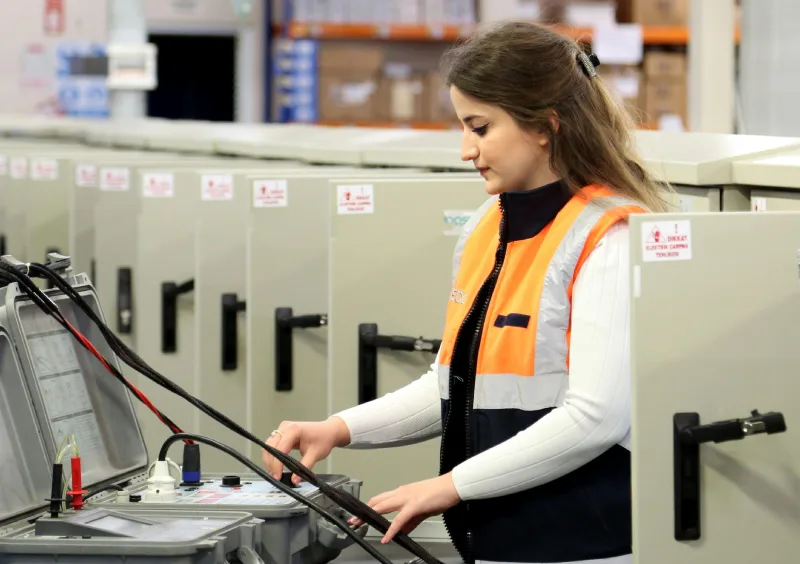 a woman fixing something on electronics how to become an electrician