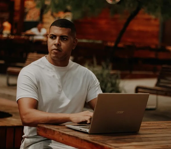 a man sitting with his laptop and searching How to Find Out If Someone Has a Warrant